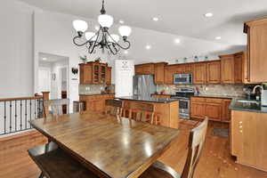 Kitchen with wood cabinets,  appliances with stainless steel finishes, quartz countertop, large island pantry, semi formal dining, great room with sliding door to backyard and plantation shutters