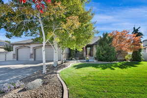 View of front of house with driveway, gated to back yard, 3 car  garage, and covered porch