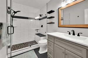 3/4  bathroom with vanity, large shower with tile bench.