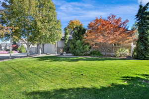 View of front facade featuring a front yard, driveway, 3 car garage and covered porch