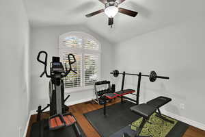 Bedroom 3 featuring vaulted ceiling, hardwood floors, ceiling fan and plantain shutters.