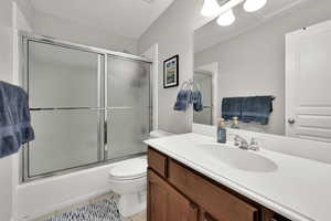 Full bath featuring  vanity, and enclosed tub / shower combo