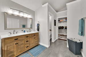 Master en suite Bathroom featuring  vaulted ceiling, a soaking tub, tile  flooring, double vanity, water closet and a walk in closet