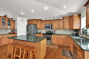 Kitchen with wood cabinets,  appliances with stainless steel finishes, quartz countertop, large island pantry, semi formal dining, great room with sliding door to backyard and plantation shutters