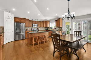 Kitchen with wood cabinets,  appliances with stainless steel finishes, quartz countertop, large island pantry, semi formal dining, great room with sliding door to backyard and plantation shutters