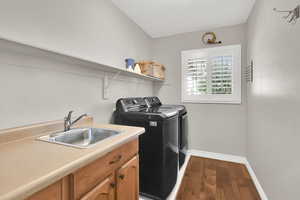Laundry room with hardwood flooring and washing machine and dryer