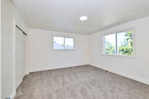 Unfurnished bedroom featuring light colored carpet, a closet, and a textured ceiling