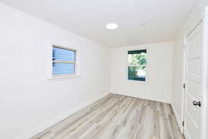 Unfurnished bedroom featuring light wood finished floors and baseboards