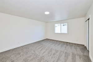 Unfurnished bedroom with carpet floors, a closet, and a textured ceiling