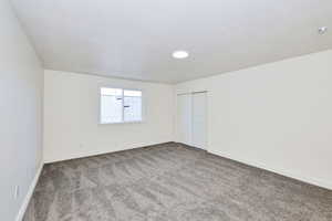 Unfurnished bedroom with carpet, a closet, and a textured ceiling