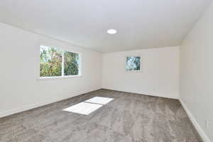 Spare room featuring light colored carpet and baseboards