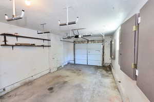 Garage with electric panel and a garage door opener