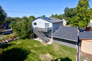 Rear view of property featuring a patio area, stairway, a deck, and a yard