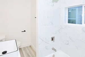 Full bathroom featuring bathing tub / shower combination and light wood finished floors