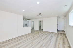 Unfurnished living room featuring light wood-style flooring, recessed lighting, and a textured ceiling