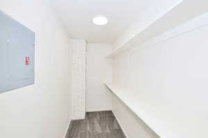 Walk in closet featuring electric panel and dark carpet