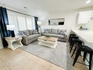 Living room featuring light tile patterned floors and baseboards
