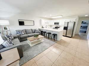 Living room with light tile patterned floors and recessed lighting