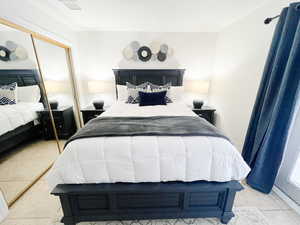Bedroom with light tile patterned floors and a closet