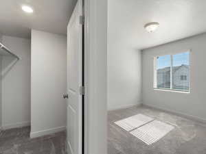 Unfurnished bedroom with light carpet and a textured ceiling