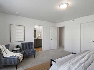 Bedroom featuring carpet flooring, a textured ceiling, and ensuite bathroom