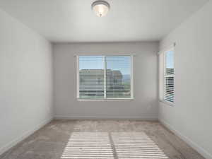 Carpeted spare room with baseboards