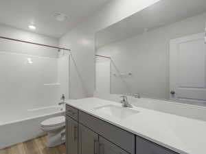 Bathroom featuring bathtub / shower combination, light wood-style floors, and vanity