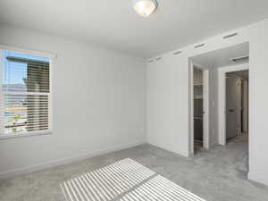 Empty room featuring light carpet and baseboards