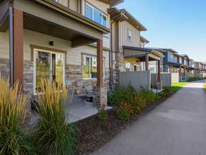 View of exterior entry featuring a residential view, board and batten siding, a porch, and stone siding