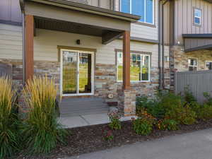 View of exterior entry with board and batten siding and stone siding