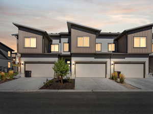View of front of property featuring concrete driveway, a garage, and board and batten siding