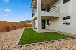 Fenced backyard featuring a balcony, a patio area, and a mountain view