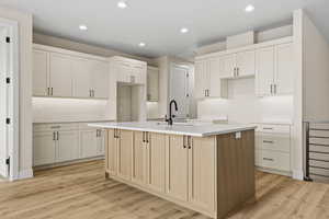 Kitchen with an island with sink, recessed lighting, light wood-style floors, and white cabinets