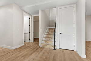 Stairway featuring wood finished floors and baseboards