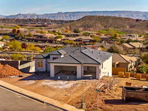 View of front facade with a mountain view, stucco siding, a residential view, a patio area, and a tiled roof