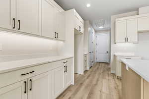Kitchen featuring white cabinetry, recessed lighting, light wood-style flooring, and light stone counters