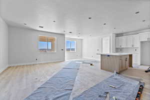 Unfurnished living room with a textured ceiling and light wood-type flooring