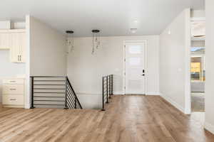 Foyer with light wood-type flooring and baseboards
