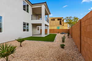 Back of property featuring a patio area, a fenced backyard, stucco siding, and a balcony
