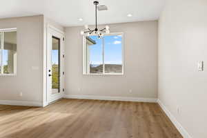 Unfurnished dining area with a chandelier, light wood-style floors, and recessed lighting