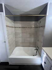 Bathroom featuring tub / shower combination, vanity, dark wood-style flooring, and a textured ceiling