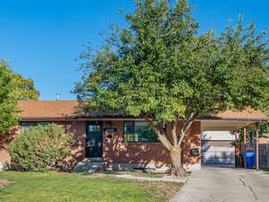 View of front with brick siding, concrete driveway, a garage, and a mountain view