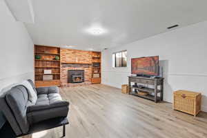 Living area featuring built in shelves, LVT flooring and fireplace