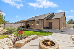 Back of house featuring a fenced backyard, a fire pit, a shingled roof, and a patio