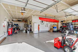 Garage featuring freestanding refrigerator and a garage door opener