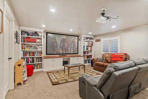 Home theater with light carpet, recessed lighting, and built in shelves