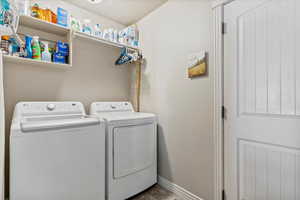Laundry room with washing machine and clothes dryer and baseboards