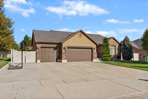 View of front facade featuring driveway, stucco siding, a gate, an attached garage, and a shingled roof