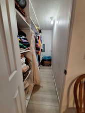 Walk in closet featuring light wood finished floors