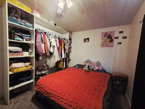 Added bedroom featuring dark colored carpet, ceiling fan, and a closet